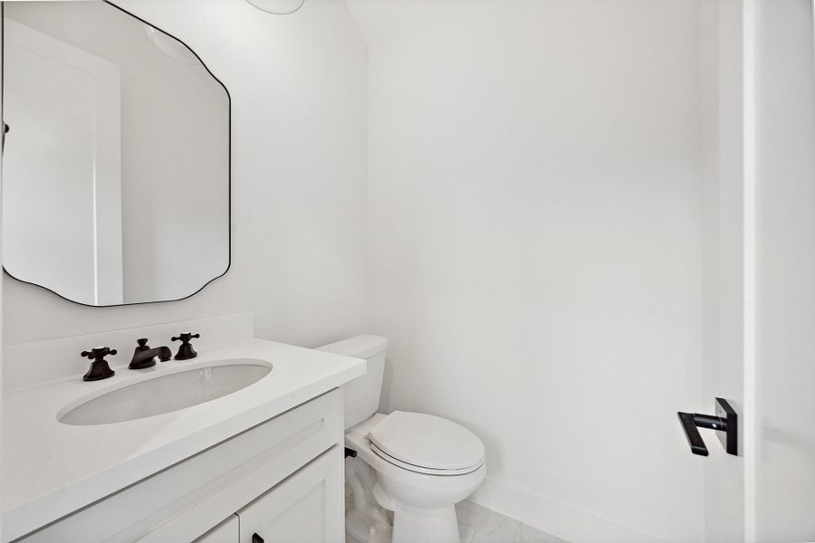 This powder bath will make your guests swoon! Elegant hardware and framed mirror bring plenty of personality and style
