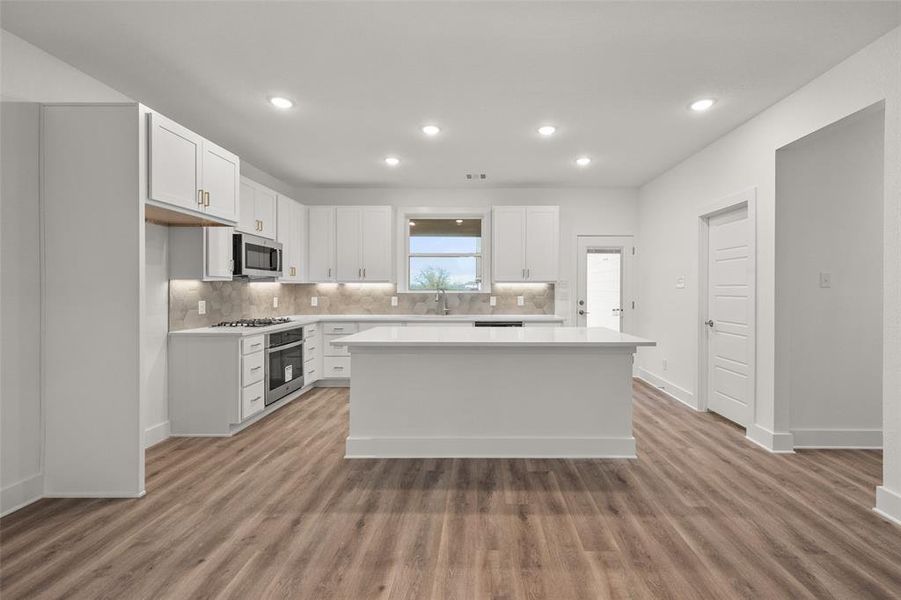 Kitchen with white cabinetry and breakfast bar