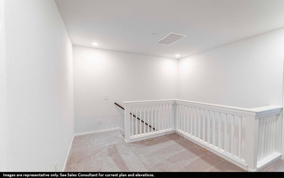 Corridor with an upstairs landing and light carpet