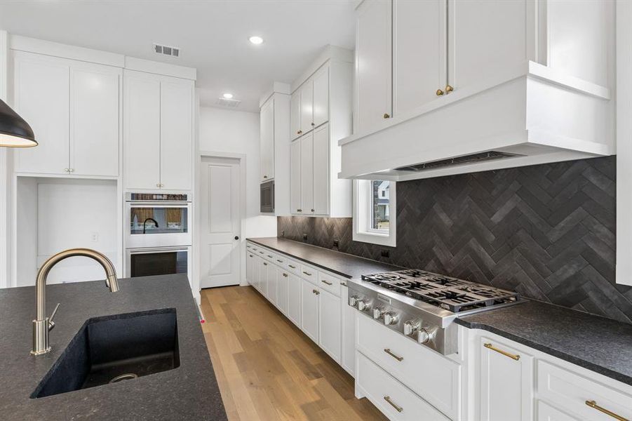 Offering a classic black and white color palette, outstanding storage and prep space, all the chef's in the family will love this dream kitchen!