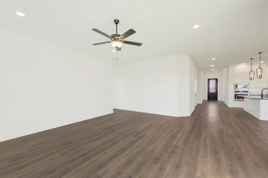 Unfurnished living room with recessed lighting, dark wood-style flooring, and ceiling fan Unfurnished living room with recessed lighting, dark wood-style flooring, and ceiling fan