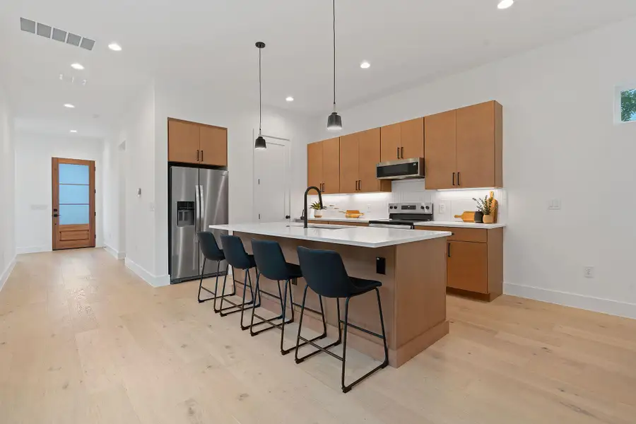 Kitchen featuring pendant lighting, decorative backsplash, an island with sink, recessed lighting, and a kitchen bar Kitchen featuring pendant lighting, decorative backsplash, an island with sink, recessed lighting, and a kitchen bar