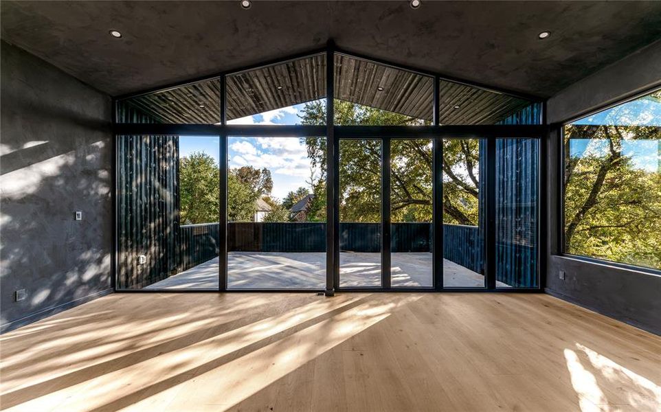 Flex room with patio, vaulted ceiling, flooded with natural light and lime wash walls.