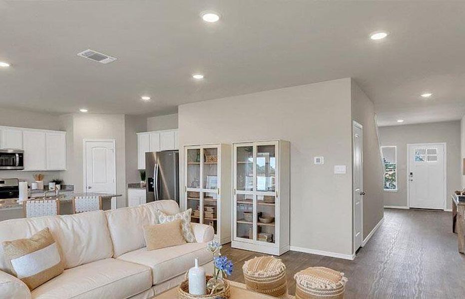Living room featuring dark wood-type flooring, recessed lighting, and baseboards Living room featuring dark wood-type flooring, recessed lighting, and baseboards