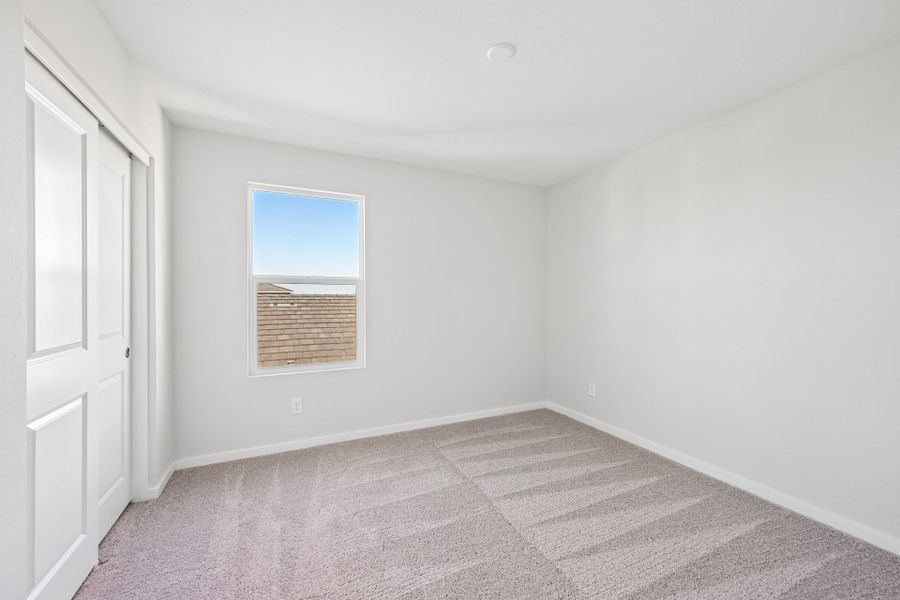 A room with a window and a rug.