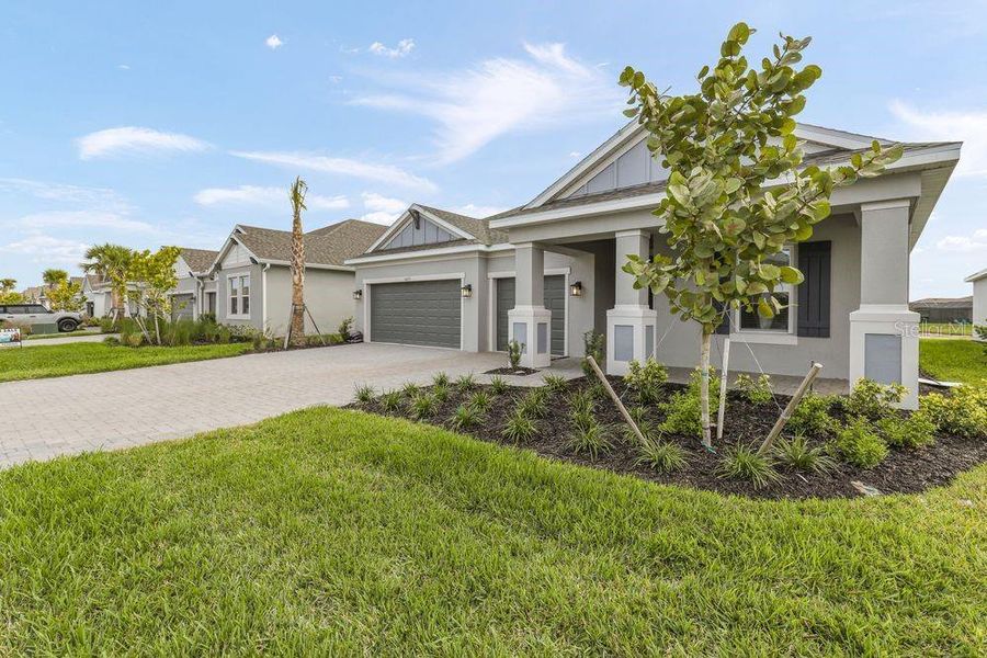 Front exterior of a new home in The Cove at West Port, Port Charlotte, FL, highlighting curb appeal (Image 1).