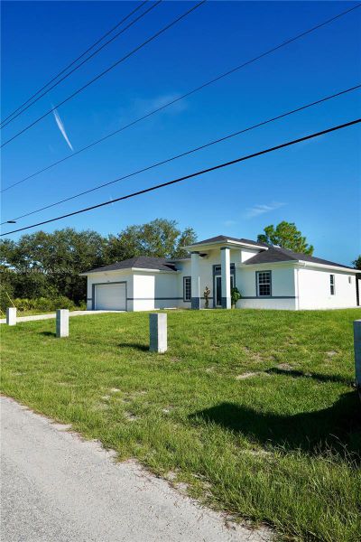 Front exterior of a new home in , Lehigh Acres, FL, highlighting curb appeal (Image 25).