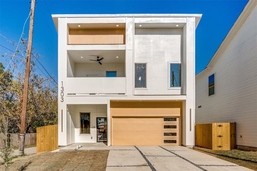 Contemporary house with ceiling fan, a garage, and a balcony