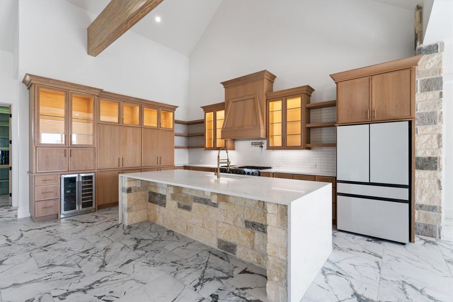 Soaring ceilings complement the kitchen's expansive stone island and custom cabinetry. Soaring ceilings complement the kitchen's expansive stone island and custom cabinetry.