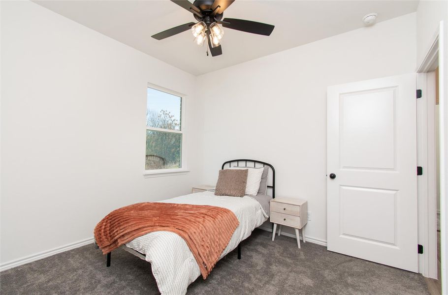 Carpeted bedroom featuring a ceiling fan