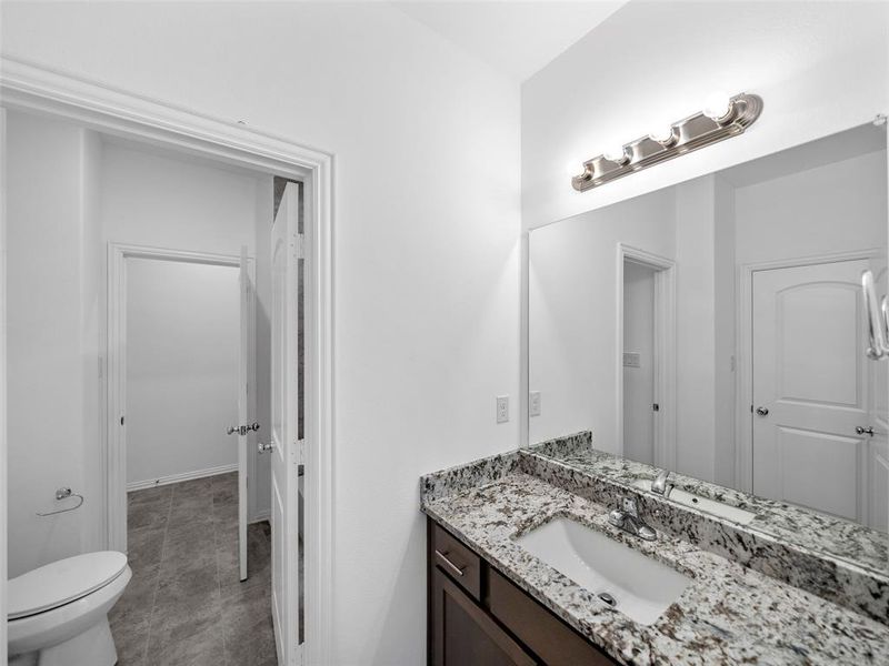 Bathroom featuring vanity, toilet, and tile patterned floors