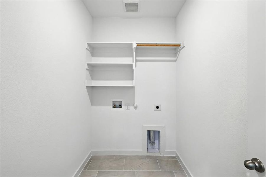Laundry room with hookup for an electric dryer, gas dryer hookup, washer hookup, and light tile patterned flooring Laundry room with hookup for an electric dryer, gas dryer hookup, washer hookup, and light tile patterned flooring