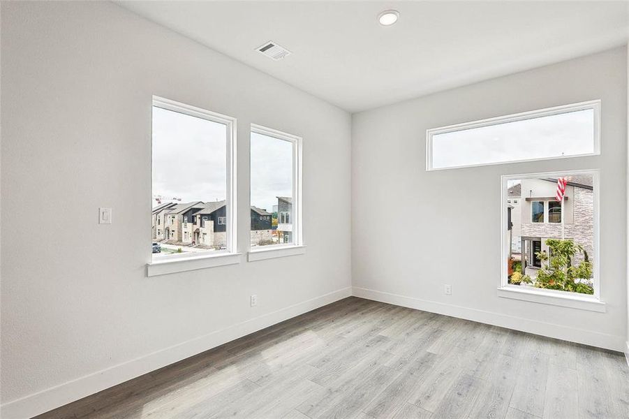 Empty room with light hardwood / wood-style flooring and a healthy amount of sunlight