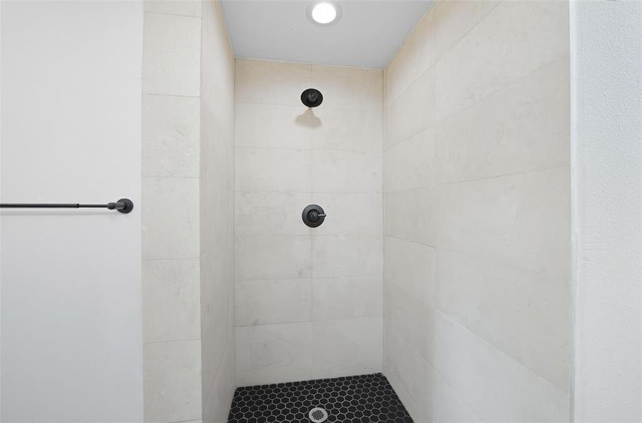 Full bathroom featuring tiled shower and recessed lighting