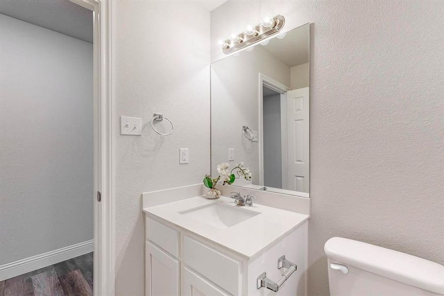 Bathroom with vanity, toilet, and hardwood / wood-style flooring