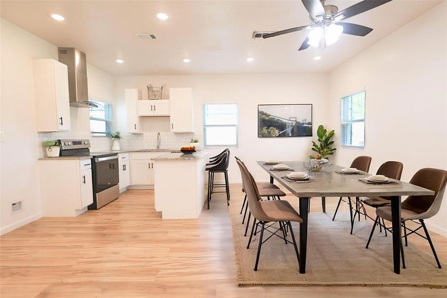 Dining room with light wood-type flooring, recessed lighting, and a ceiling fan