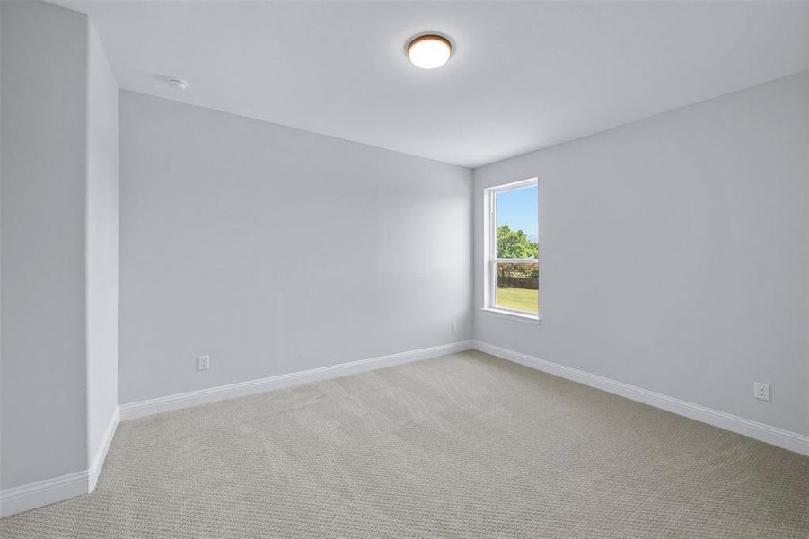 Spare room with light colored carpet and baseboards