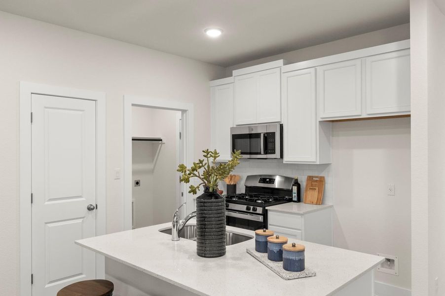 A contemporary kitchen offers a functional island with a sink, perfect for meal prep or casual dining.