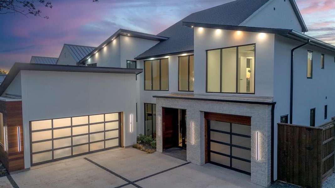 Contemporary house with a garage, stucco siding, driveway, brick siding, and a standing seam roof Contemporary house with a garage, stucco siding, driveway, brick siding, and a standing seam roof