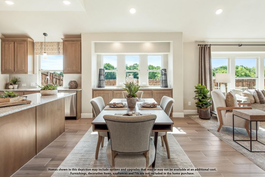 Open-concept dining area with wood-look tile floors, adjacent kitchen with brown cabinets, and living room with large windows