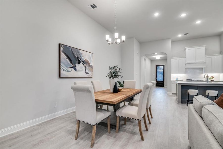 Dining room featuring an inviting chandelier and light wood-type flooring