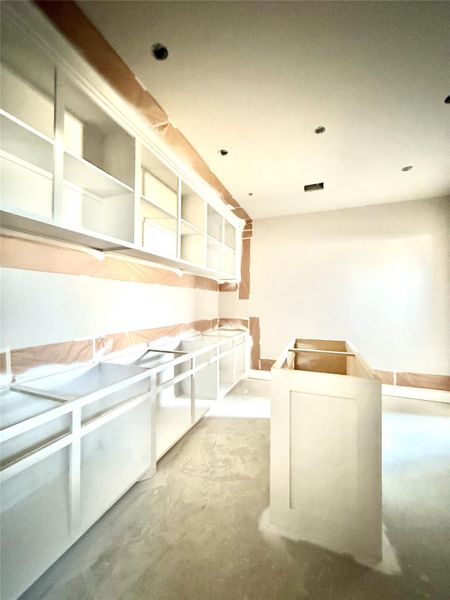 Oversized Primary Closet with 2 sided entry, built in shelves and island