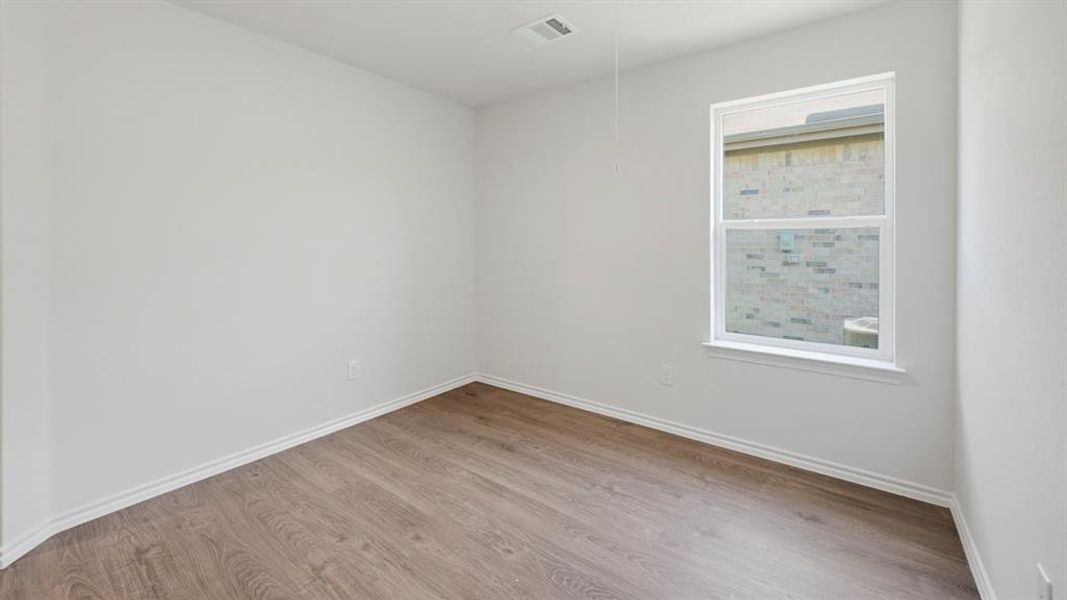 Spare room featuring wood finished floors and baseboards Spare room featuring wood finished floors and baseboards