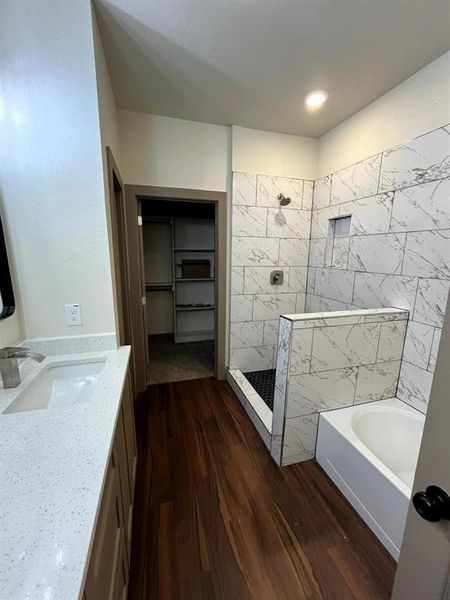 Bathroom with vanity, a walk in shower, a garden tub, dark wood-style flooring, and a spacious closet Bathroom with vanity, a walk in shower, a garden tub, dark wood-style flooring, and a spacious closet