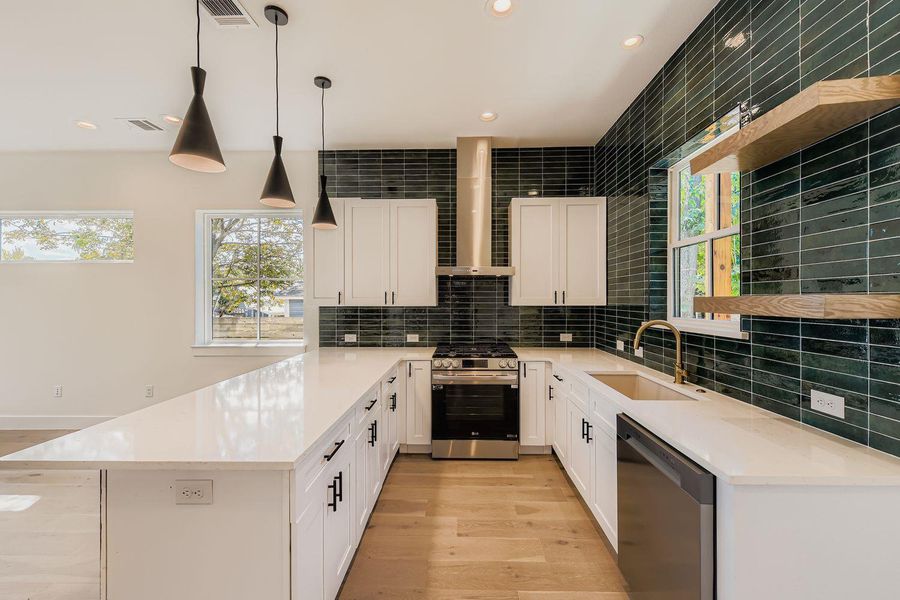 Kitchen with backsplash, stainless steel appliances, a peninsula, light wood-type flooring, and recessed lighting Kitchen with backsplash, stainless steel appliances, a peninsula, light wood-type flooring, and recessed lighting