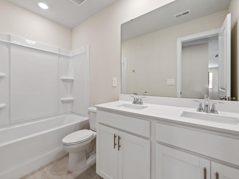 The secondary bathroom boasts a dual-sink vanity and oversized shower tub. The secondary bathroom boasts a dual-sink vanity and oversized shower tub.