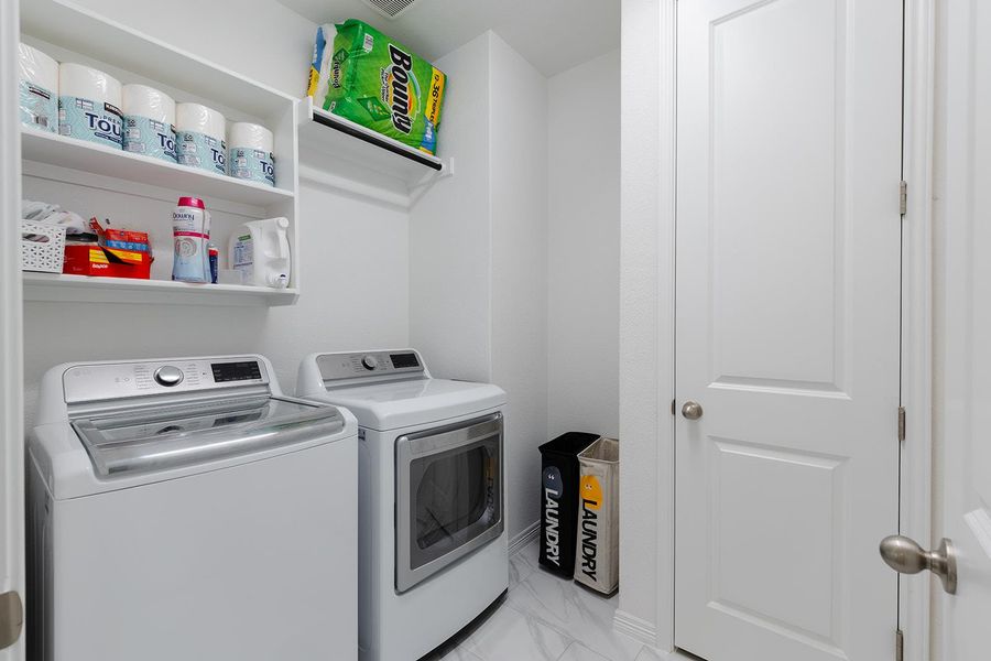 Washroom featuring washing machine and dryer and light marble finish floors