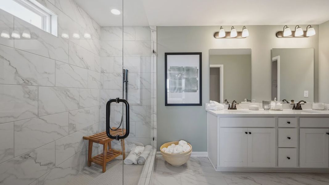Stylish bathroom with walk-in shower, double vanity, and modern fixtures in Langley Overlook townhome in Loganville, GA. Stylish bathroom with walk-in shower, double vanity, and modern fixtures in Langley Overlook townhome in Loganville, GA.