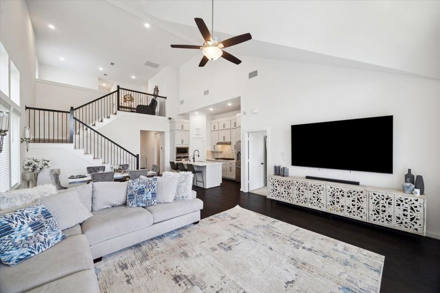 AN OPEN-CONCEPT VIEW FROM THE LIVING ROOM HIGHLIGHTS THE DARK WOOD FLOORING AND THE TRANSITION INTO THE KITCHEN AND DINING AREAS.