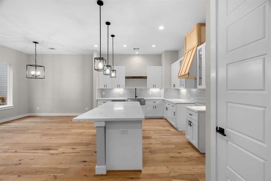 Artic white quartz kitchen island. Black light fixtures