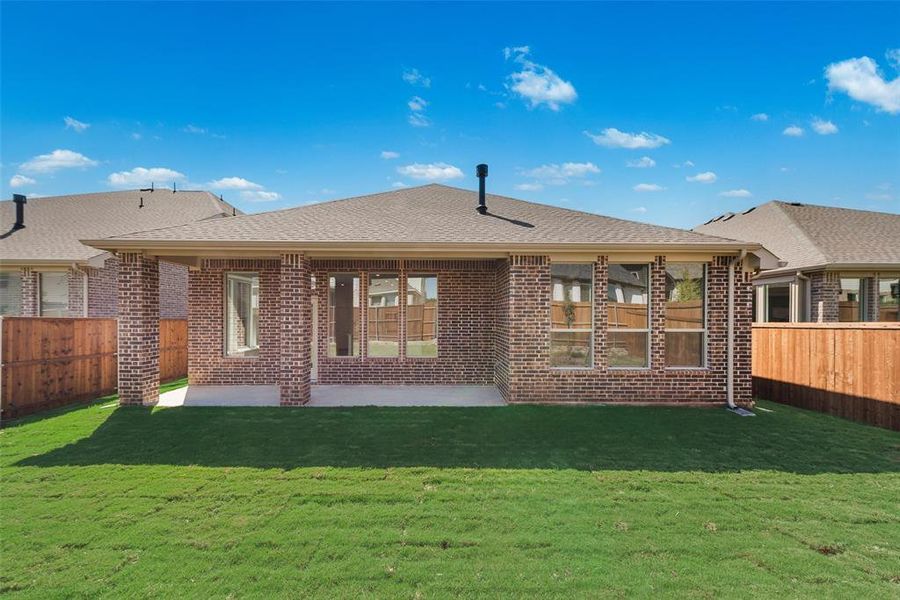 Rear view of house with a patio area and a yard