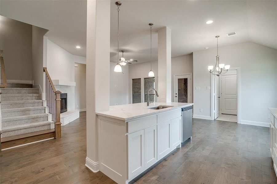 Kitchen featuring dishwasher, light stone countertops, dark hardwood / wood-style flooring, white cabinetry, and sink