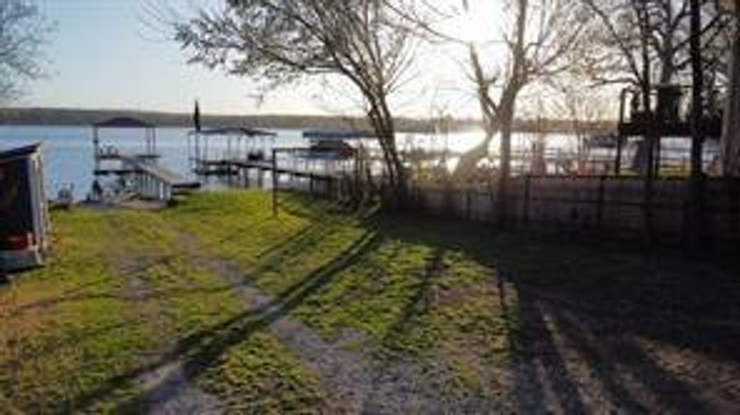 View of yard with fence and a water view