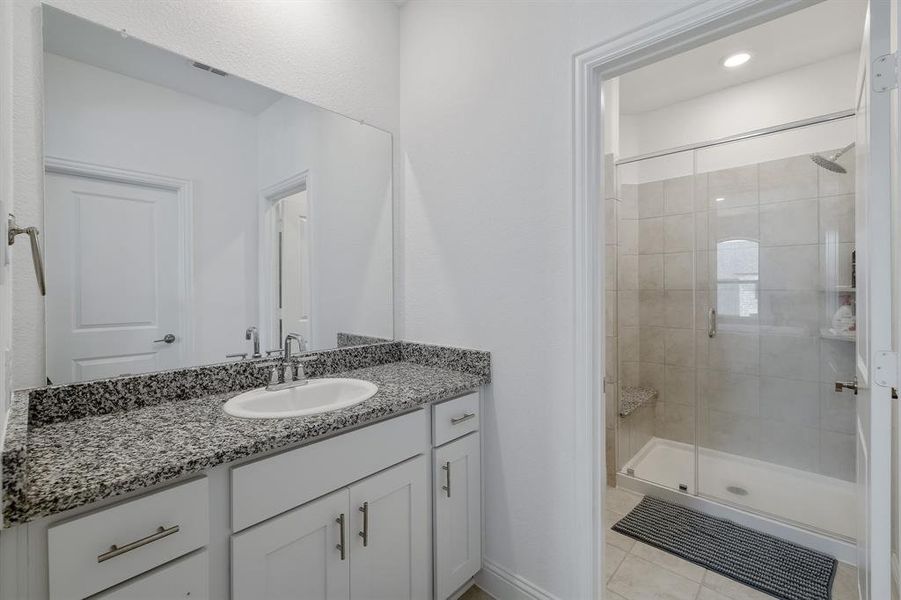 Bathroom featuring a stall shower, tile patterned floors, visible vents, and vanity