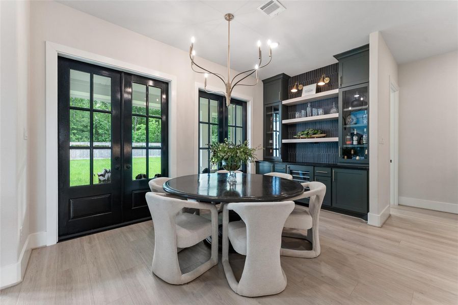 This dining view highlights the strong indoor outdoor connection and convenient flow between the kitchen, living room, and covered patio. The nearby butler’s pantry supports effortless entertaining.