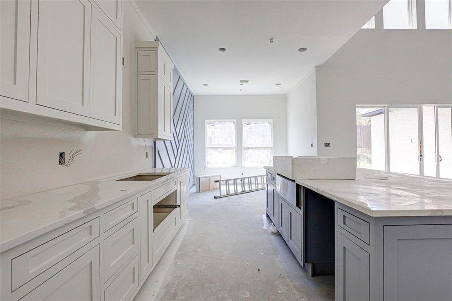 Kitchen featuring light stone countertops and gray cabinetry