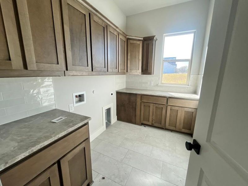 Laundry area with washer hookup, cabinet space, hookup for an electric dryer, and hookup for a gas dryer