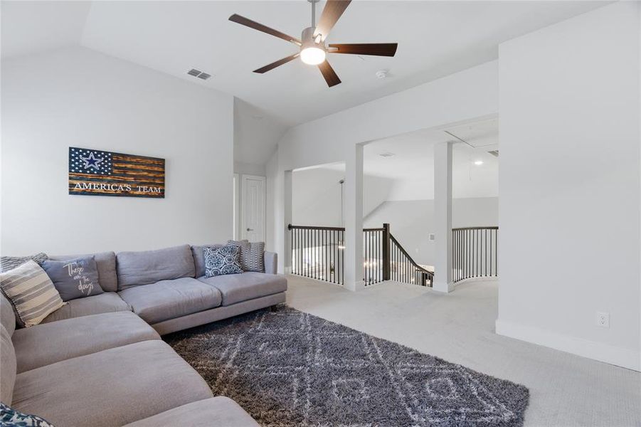 Spacious bonus room featuring vaulted ceilings, a ceiling fan with integrated lighting, and carpet flooring