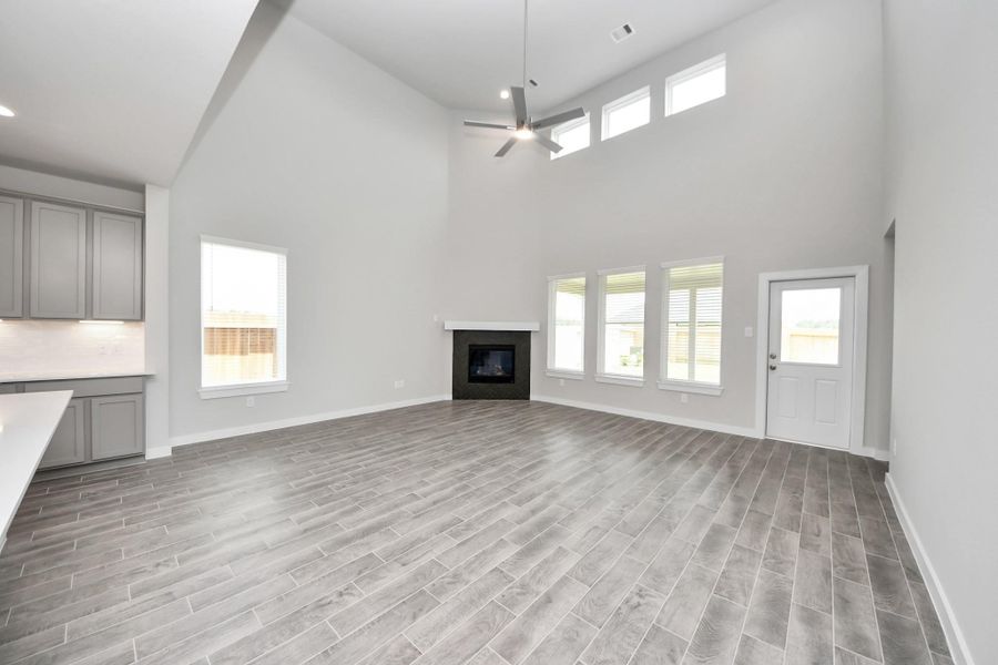 Welcome family and guests to your charming living room! With its high ceilings, recessed lighting, ceiling fan, custom paint, beautiful flooring, and large windows that let in abundant natural light, this room is perfect for gatherings. Sample photo of completed home with similar floor plan. Actual colors and selections may vary. Welcome family and guests to your charming living room! With its high ceilings, recessed lighting, ceiling fan, custom paint, beautiful flooring, and large windows that let in abundant natural light, this room is perfect for gatherings. Sample photo of completed home with similar floor plan. Actual colors and selections may vary.