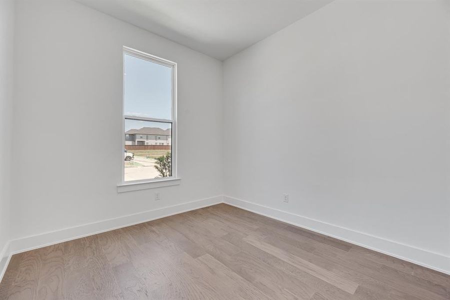 Empty room with light wood-style floors and baseboards Empty room with light wood-style floors and baseboards