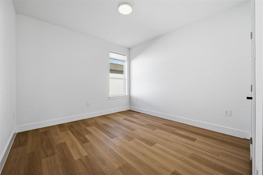 Secondary Bedroom features flush-mount lighting. Window provides natural light throughout the room. Vinyl flooring extends throughout.