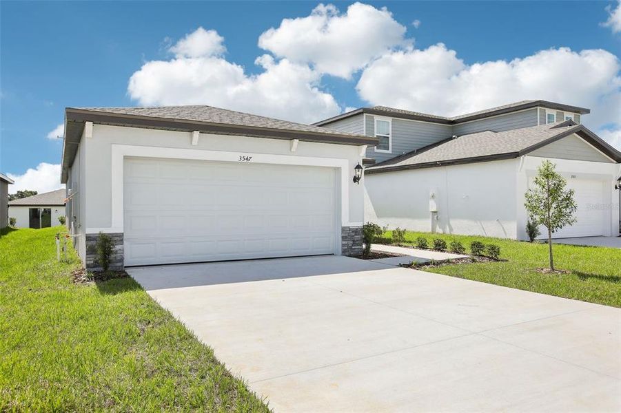 Front exterior of a new home in Benton Hills - Classic Series, Brooksville, FL, highlighting curb appeal (Image 2). Front exterior of a new home in Benton Hills - Classic Series, Brooksville, FL, highlighting curb appeal (Image 2).