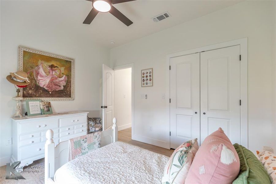 Bedroom with light wood finished floors, a ceiling fan, and a closet Bedroom with light wood finished floors, a ceiling fan, and a closet