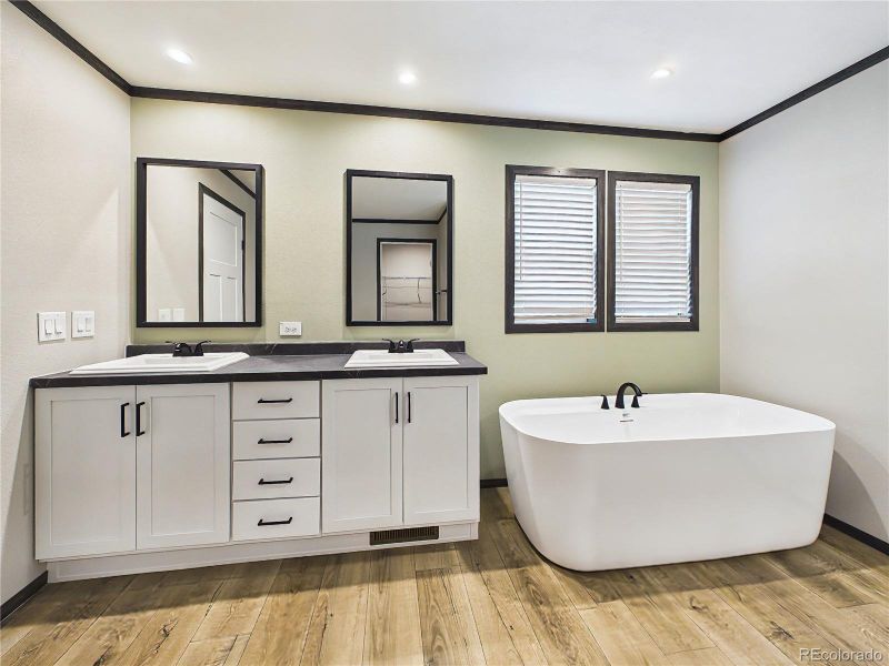 Primary Bathroom (Soaking Tub) – Freestanding soaking tub positioned beneath dual windows, creating a bright and spa-like atmosphere.
