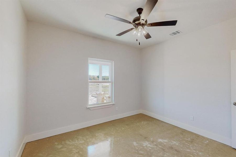 Empty room featuring concrete floors and ceiling fan