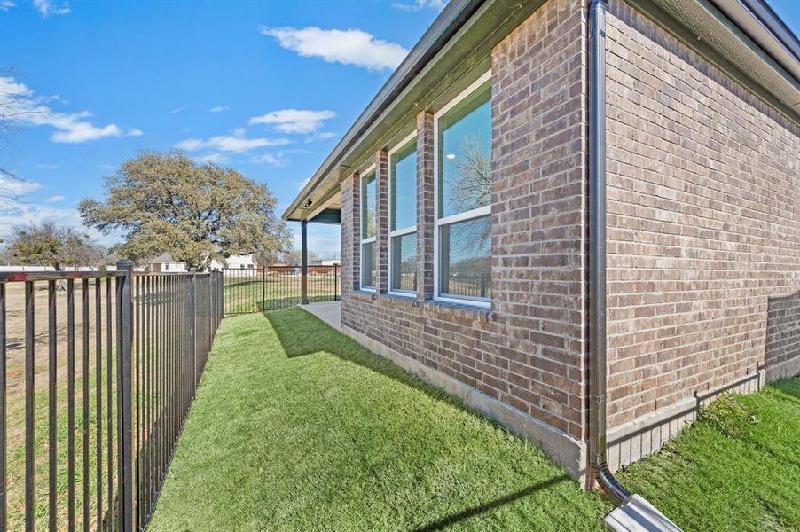 View of side of home with brick siding and a fenced backyard